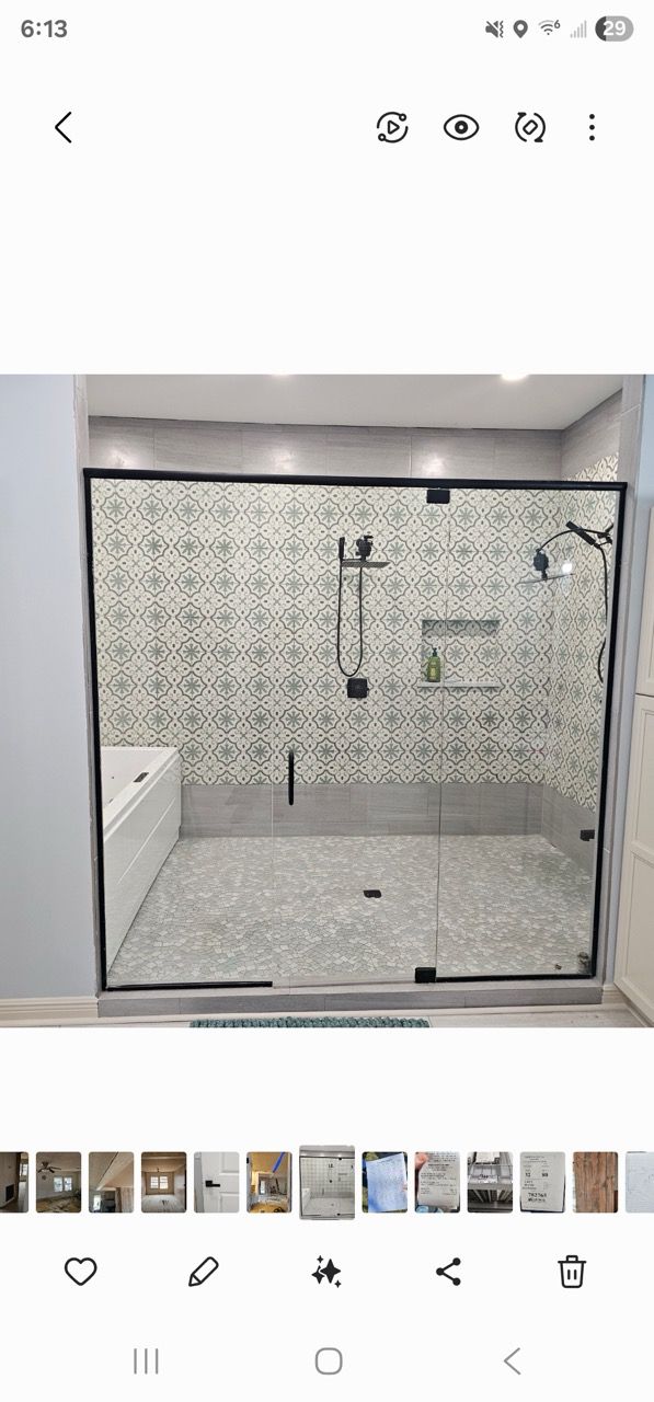 Modern shower with mosaic tile walls, glass enclosure, and chrome fixtures