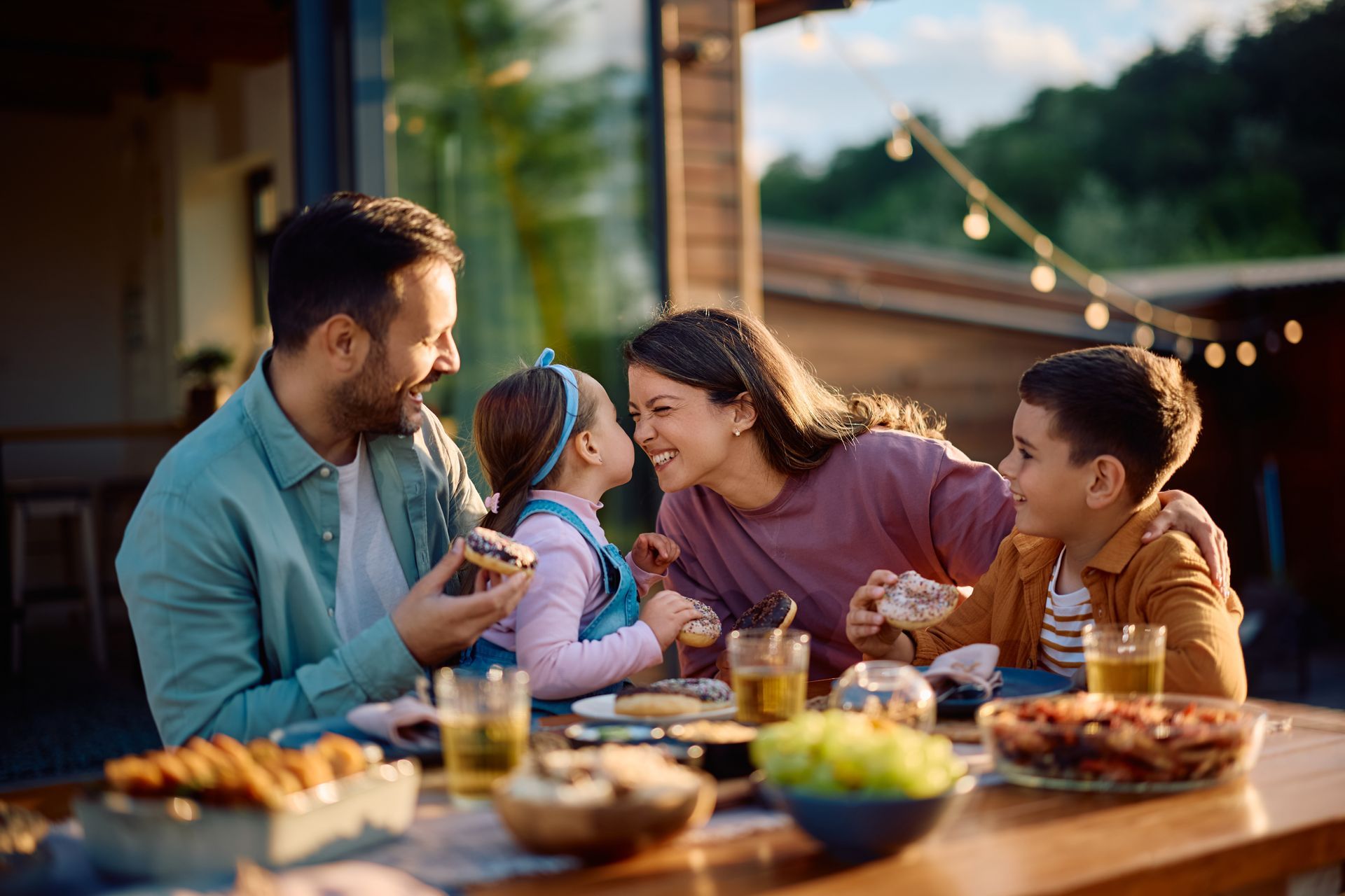 Family smiles at each other during an outdoor mea