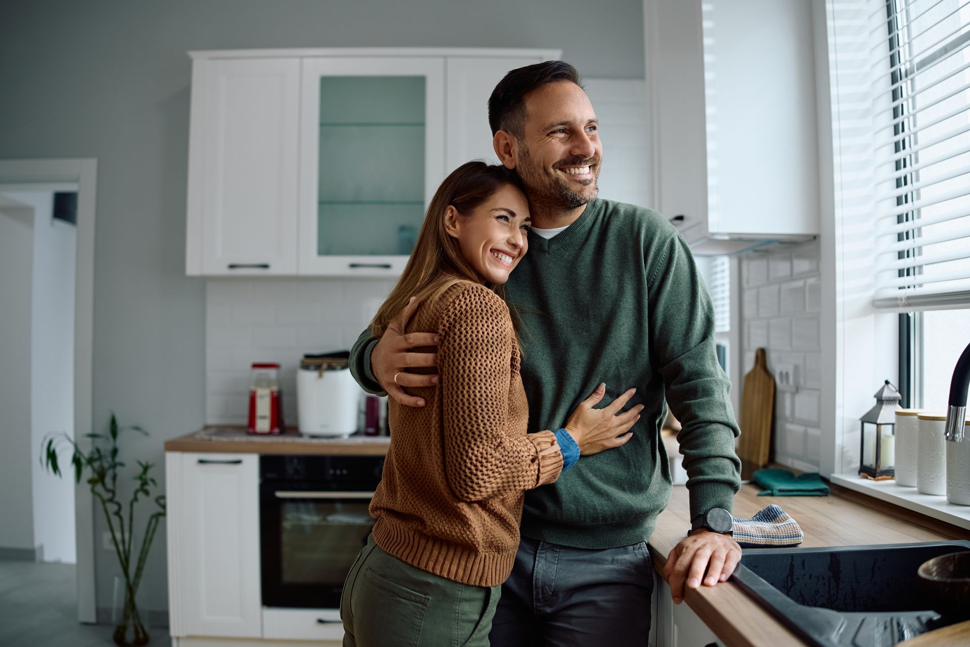 Couple embracing in a kitchen,