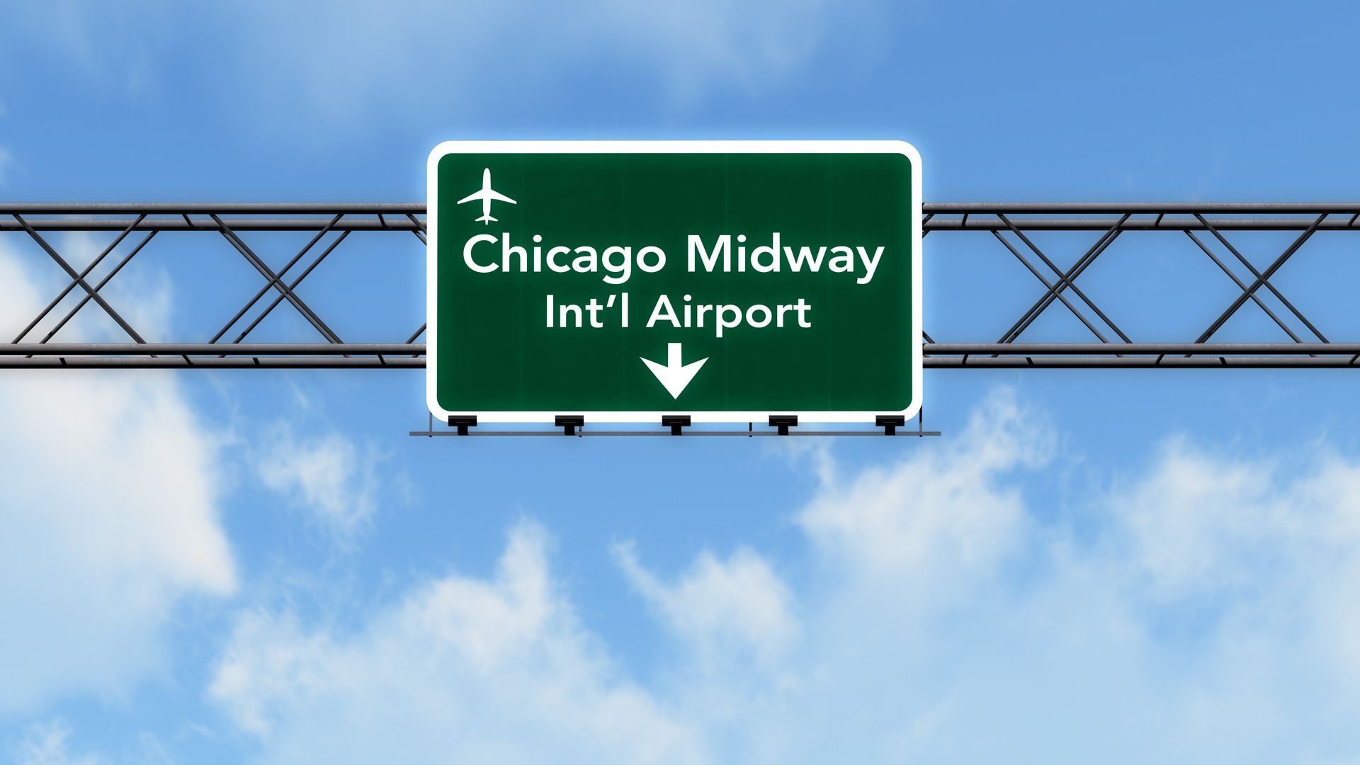 A green highway sign points to chicago midway airport
