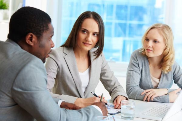A group of people are sitting around a table having a meeting