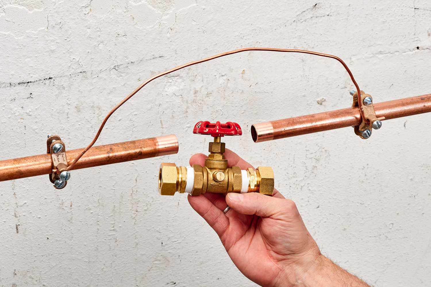 man hand holding Shut-off with two pipes side by side