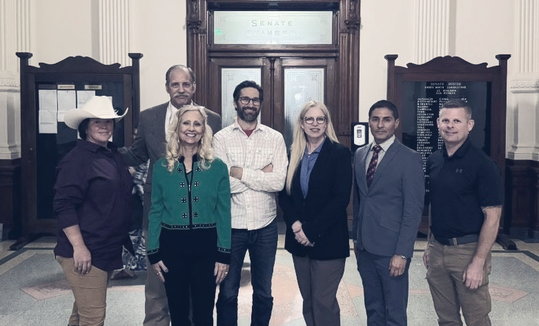 A group of seven people, including Jennifer Lundy, standing in a line smiling.