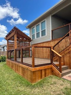 A house with a wooden deck and stairs in front of it.