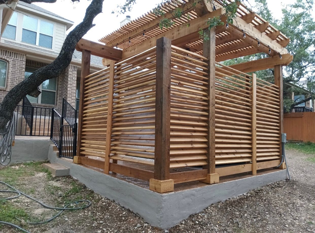 A wooden pergola is sitting in the backyard of a house.