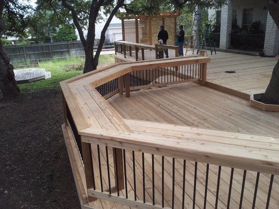 A wooden deck with a metal railing and stairs