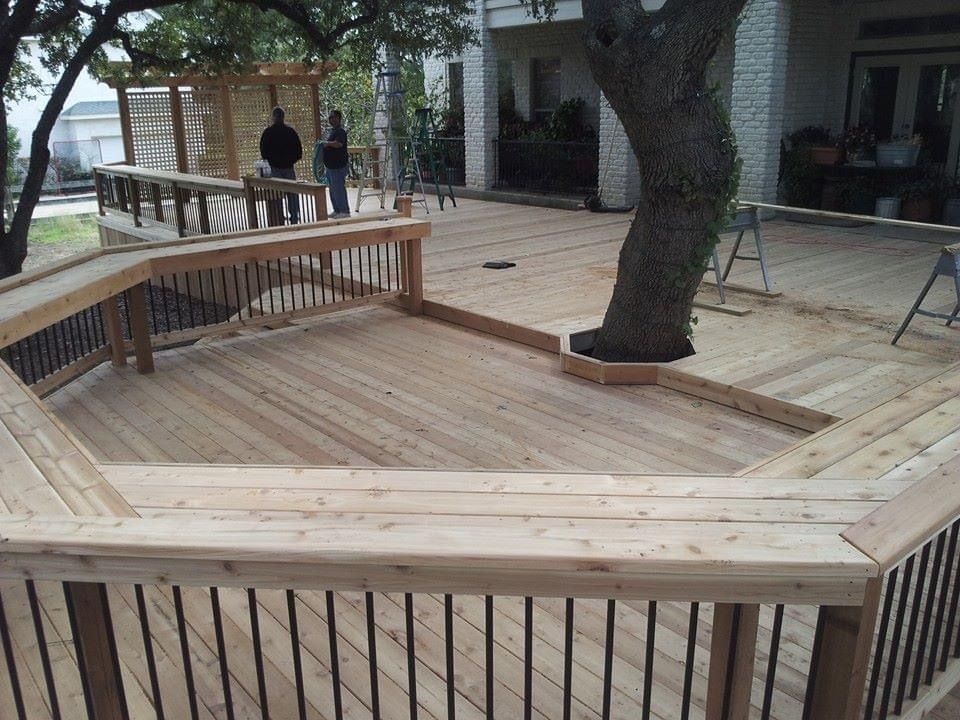 A wooden deck with a tree in the middle of it