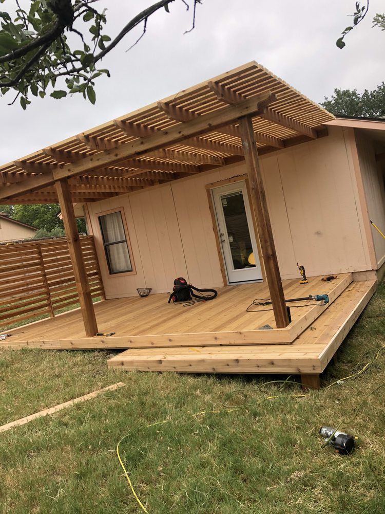 A wooden deck is being built in front of a house.