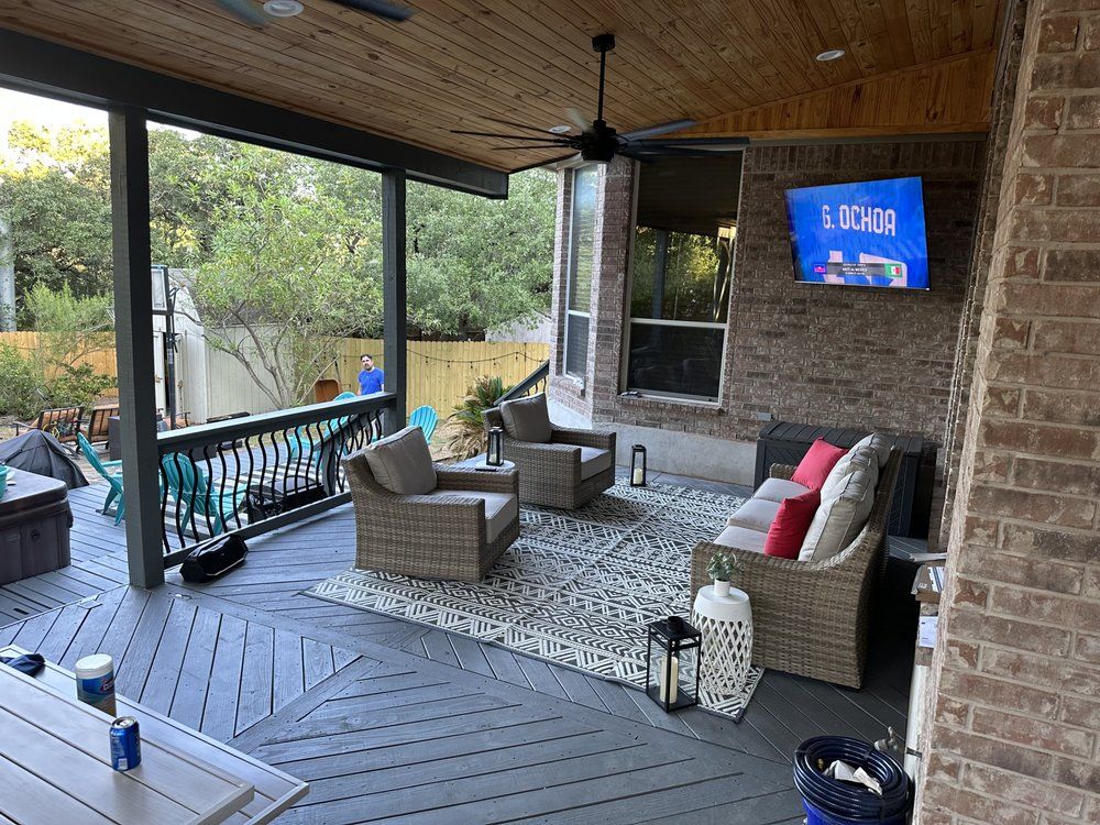 A screened in porch with furniture and a flat screen tv.