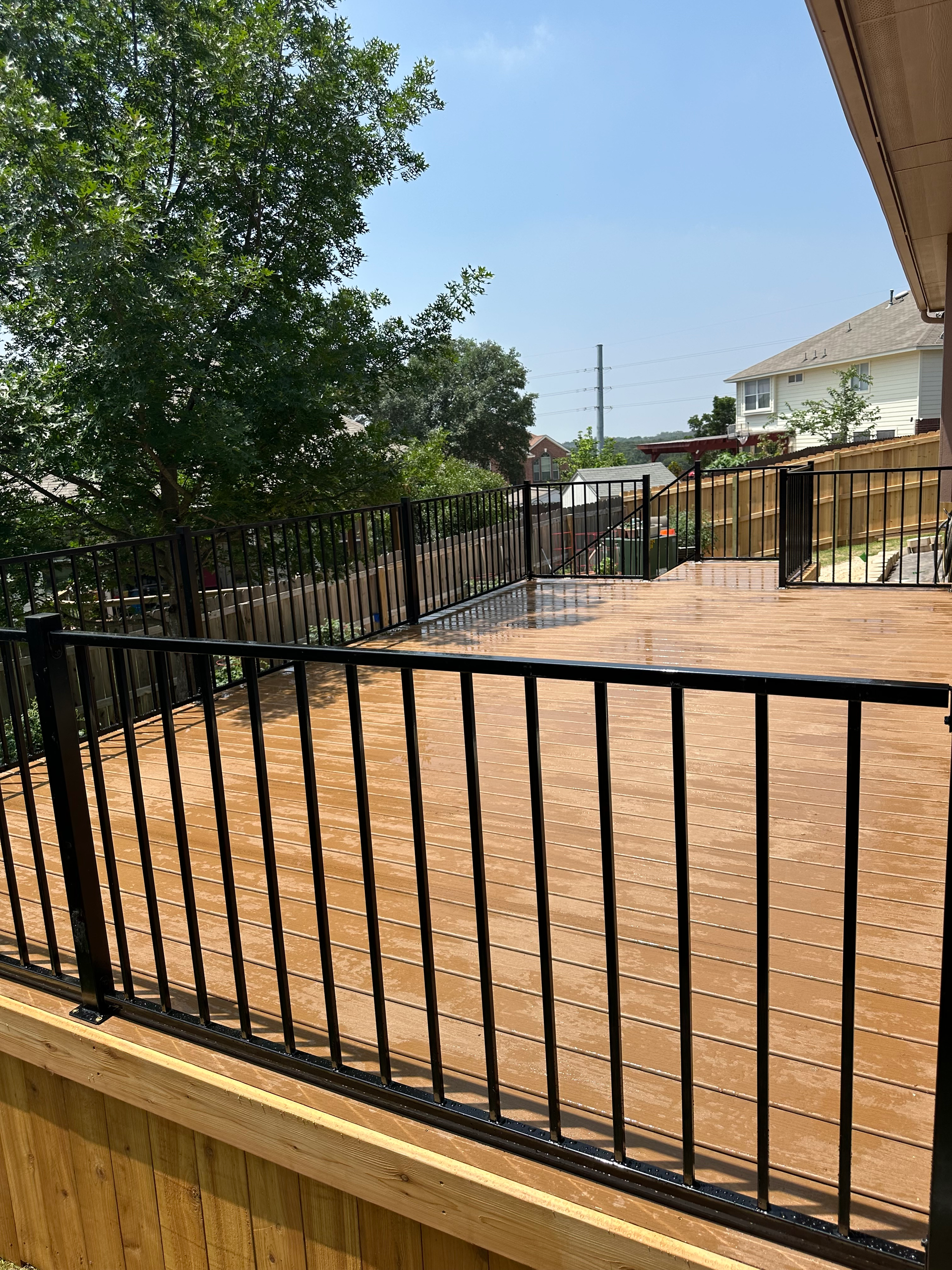 A view of a deck from a balcony with a wrought iron railing.