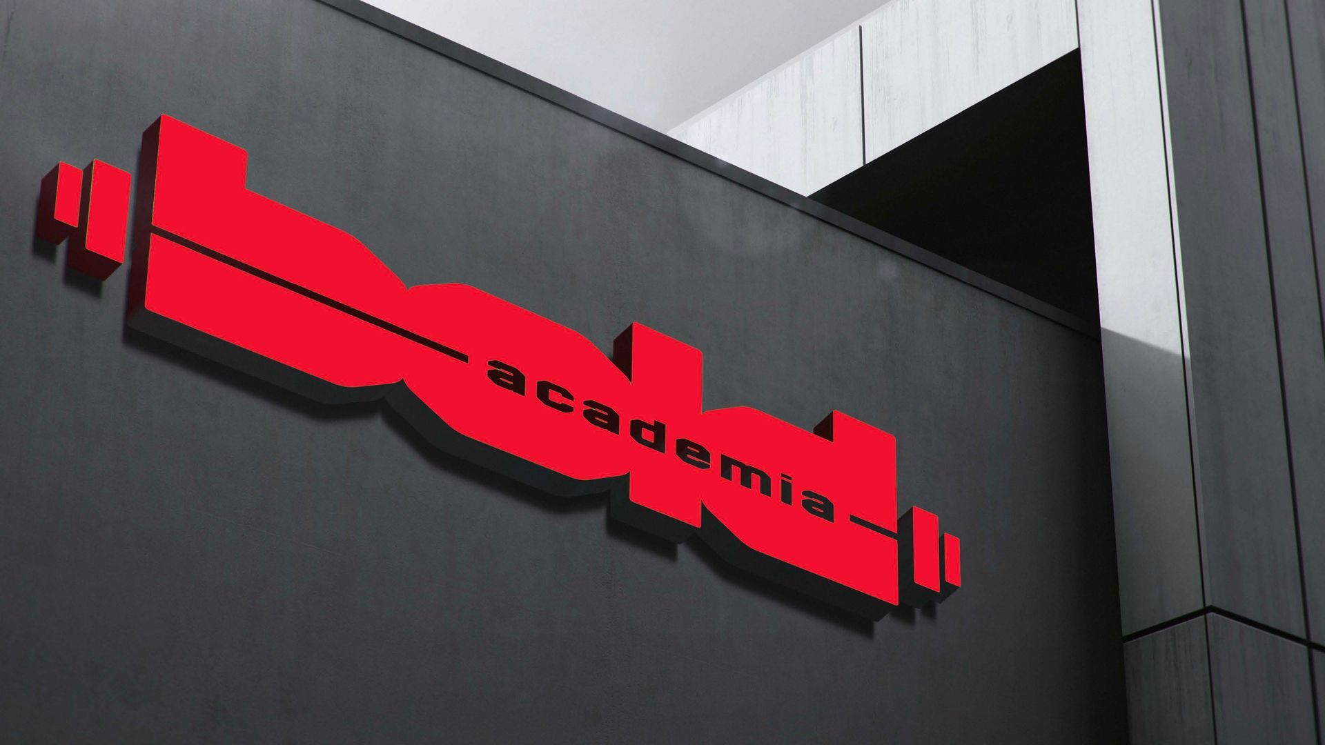 Placa vermelha com a palavra “academia” afixada na fachada cinza de um prédio.