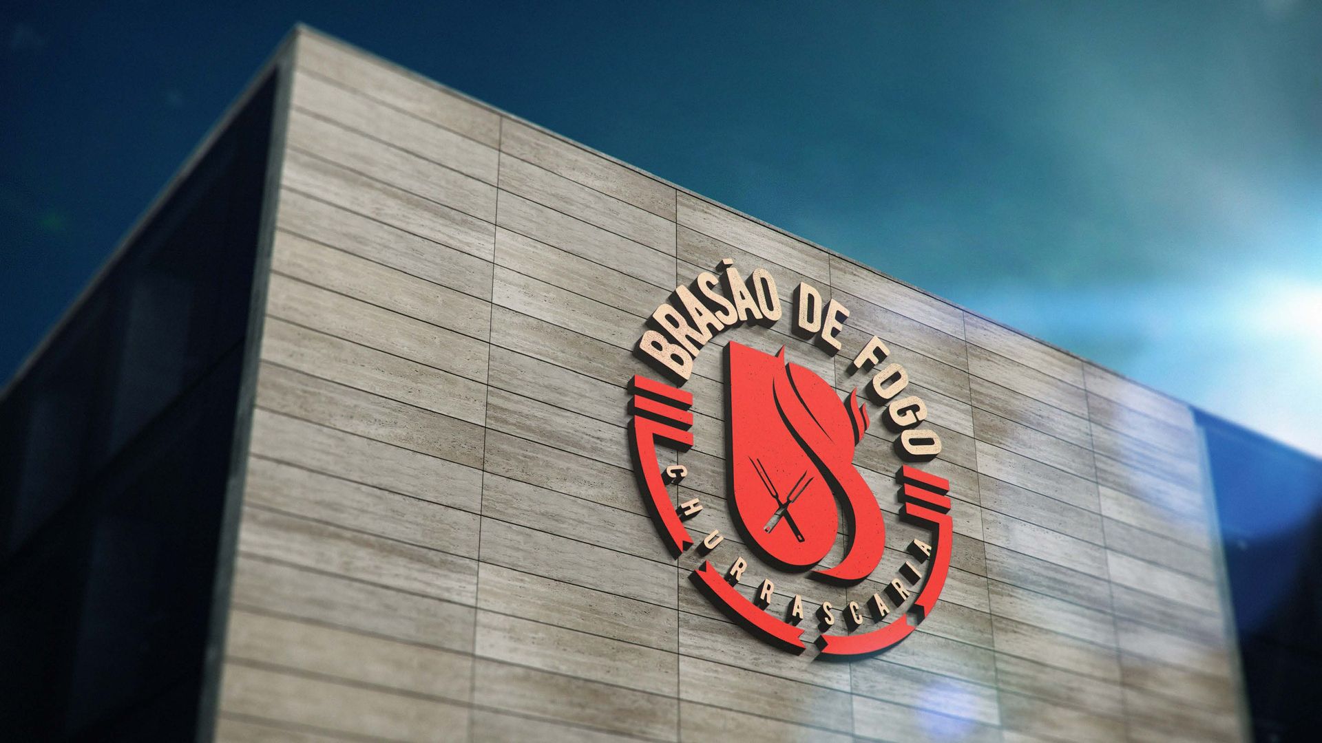 Logotipo da Brasão de Fogo na lateral de um prédio moderno sob um céu azul brilhante. O logotipo apresenta uma chama vermelha e texto dentro de um círculo vermelho.