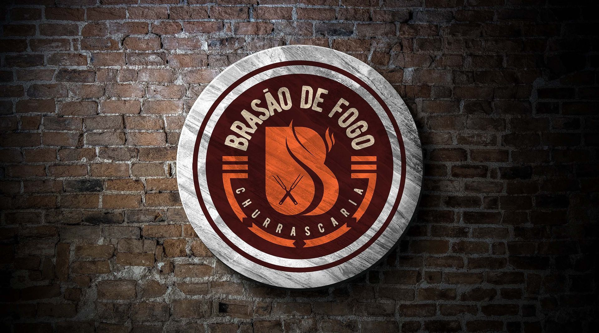 Logo for Brasão de Fogo, a restaurant, on a brick wall. The logo is a circular badge with text and a flame design.