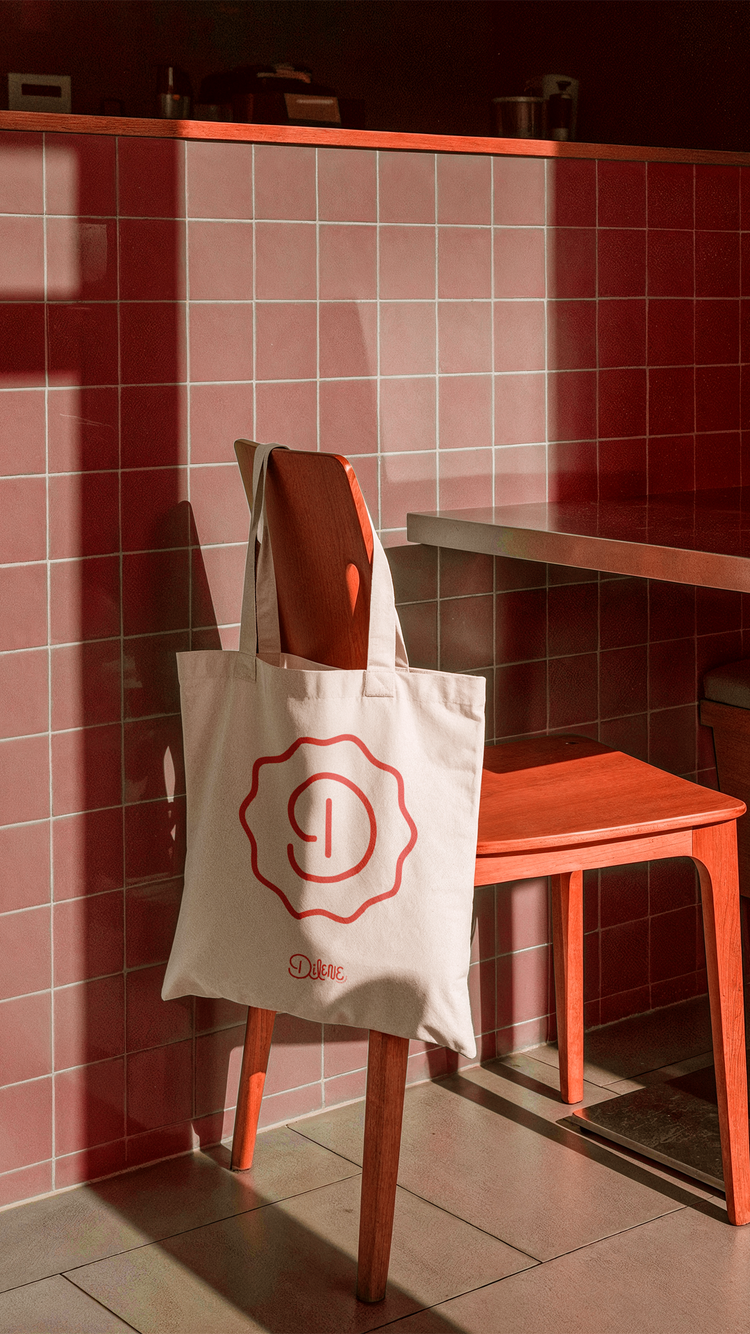 Uma sacola de compras branca sobre uma cadeira em uma sala com azulejos vermelhos, ao lado de um banco laranja.