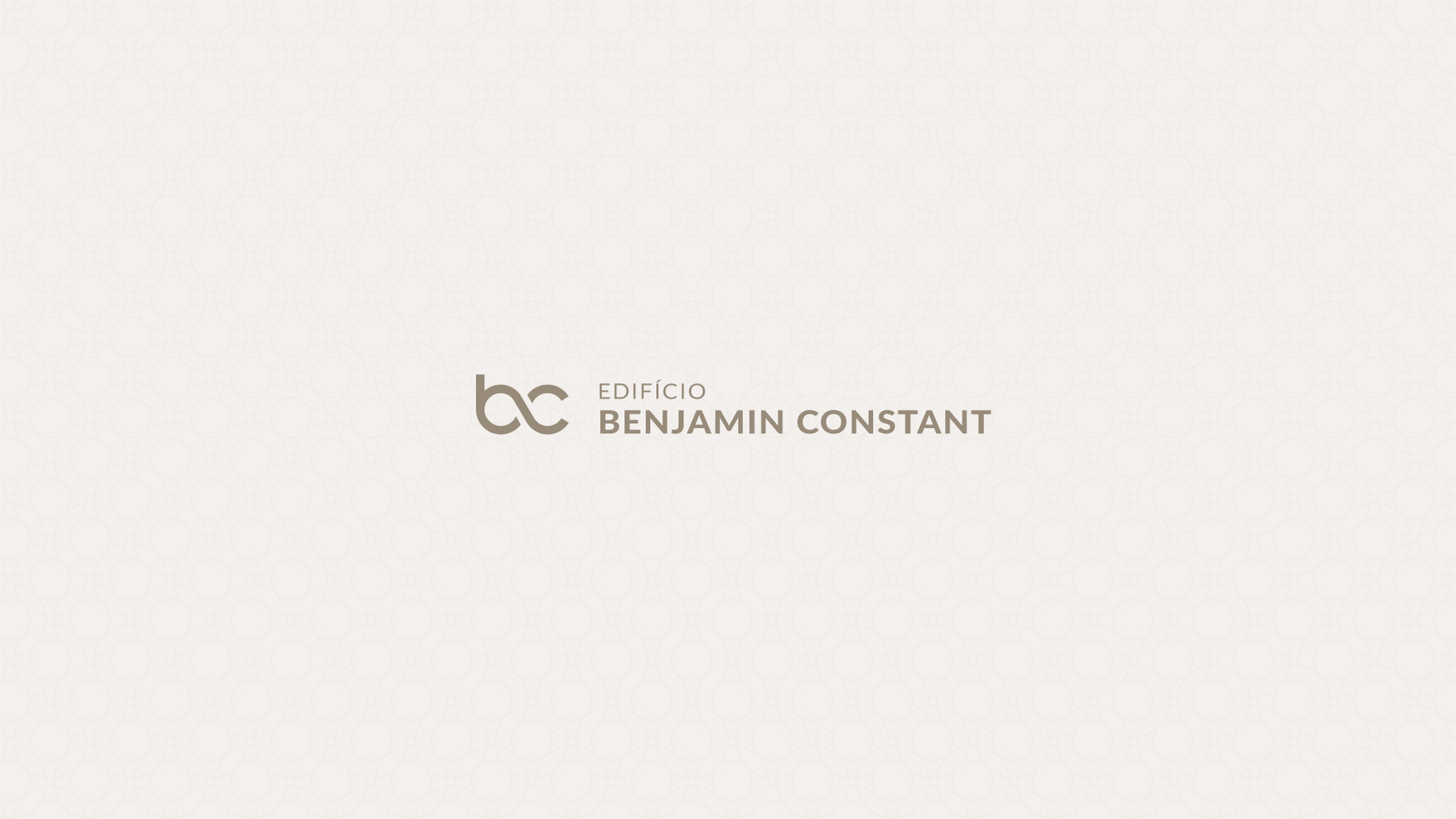 Logotipo da Benjamin Constant em cinza sobre fundo bege claro.