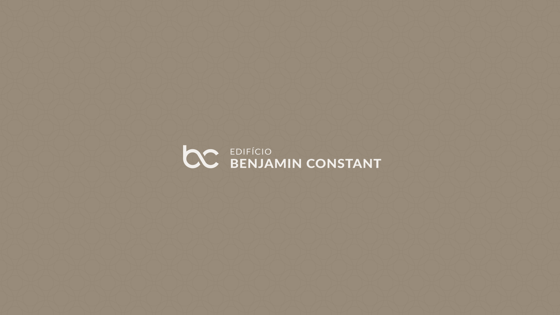 Logotipo da Benjamin Constant em fundo bege com texto e monograma em branco.
