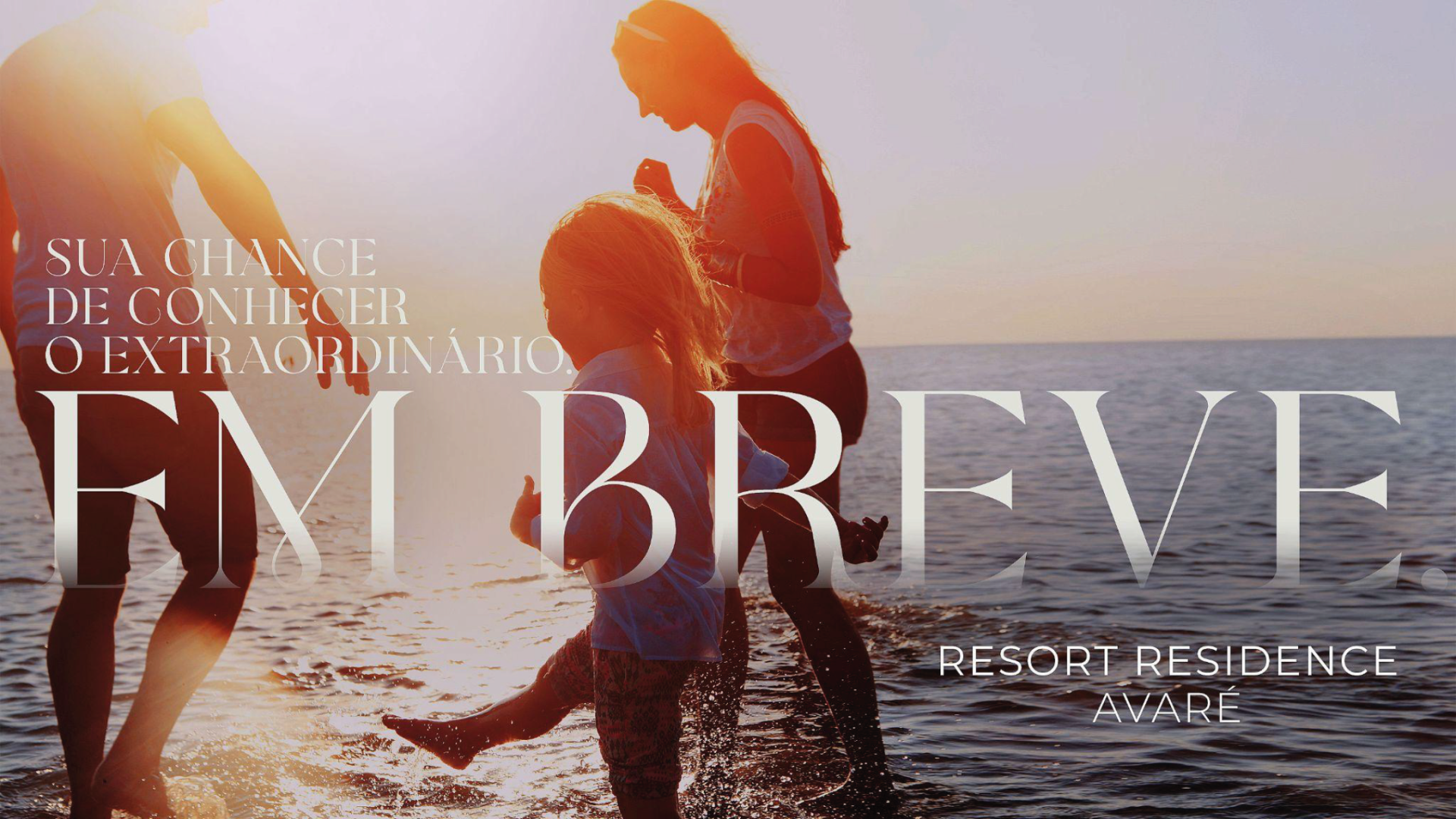 A family playing in the ocean at sunset. Text overlay: 