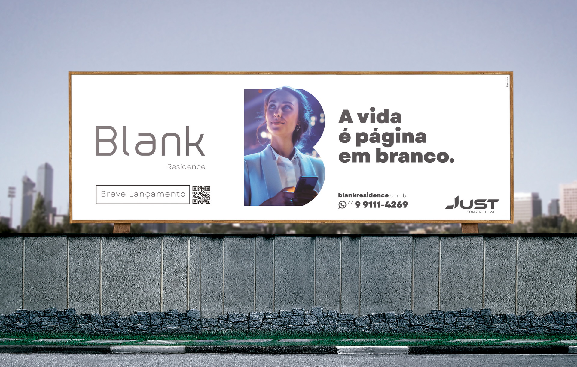 Billboard ad with “Blank” and “A vida é a página em branco.” over a city wall.