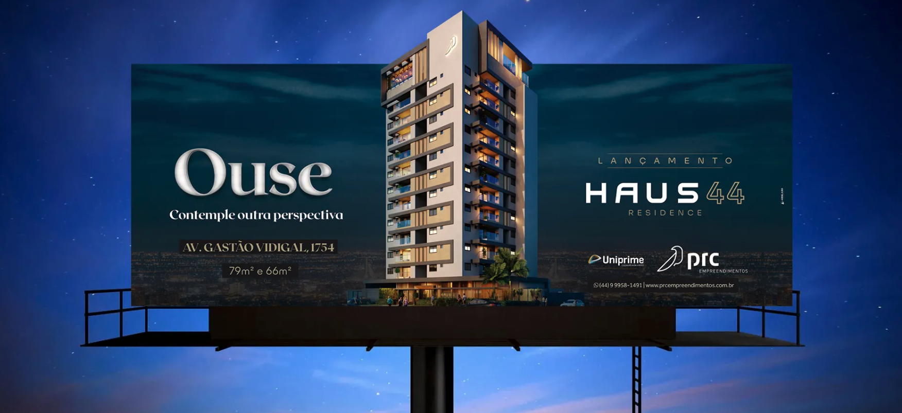 Anúncio em outdoor dos condomínios Ouse e Haus 44 à noite, contra um céu azul.