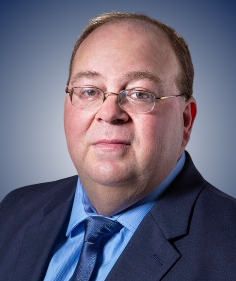 a man in a suit and tie is wearing glasses .
