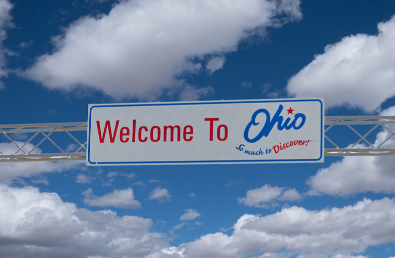 Welcome to Ohio roadside sign against a blue sky with clouds