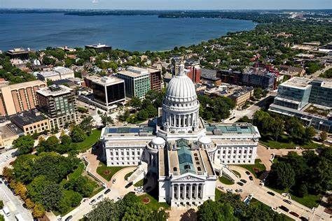 Aerial view of the Wisconsin State Capitol building in Madison, with a lake in the background.