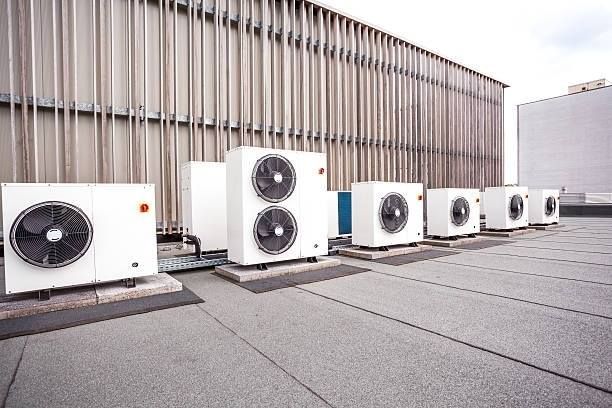 Technician checking HVAC gauges and wiring in an outdoor mechanical unit