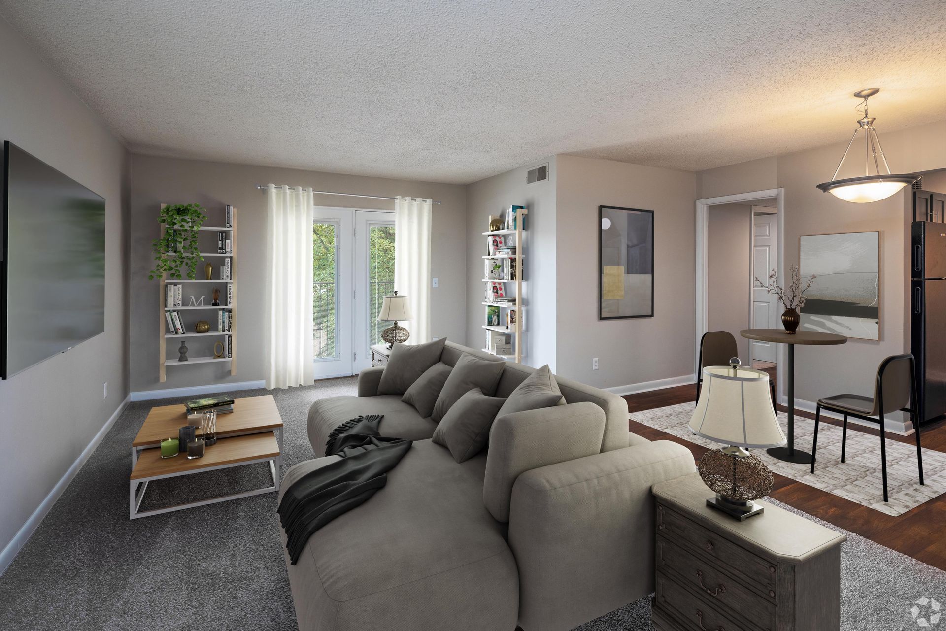 A modern living room with a gray sectional, two-tiered wooden coffee table, wall shelves, and a small dining area.
