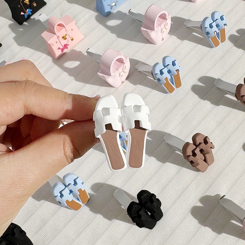 A person is holding a pair of ice cream hair clips