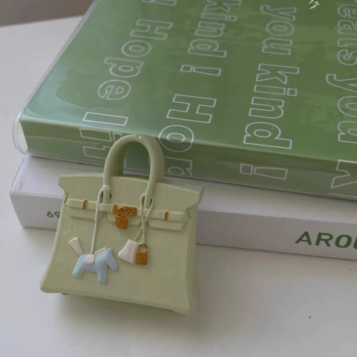 A small purse is sitting on top of a stack of books.