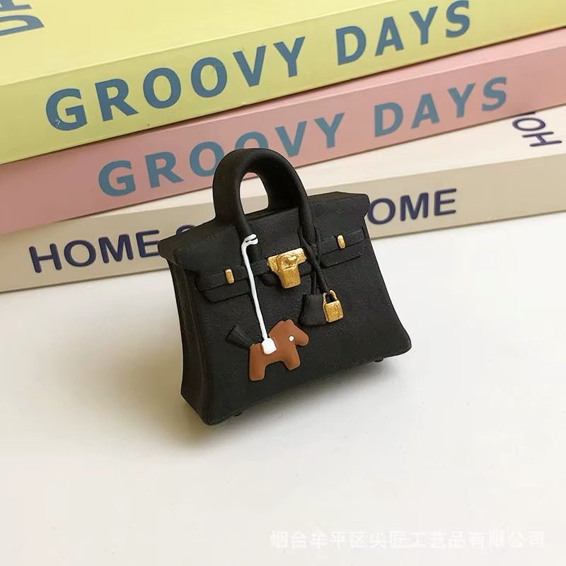 A black purse is sitting on top of a stack of groovy days books