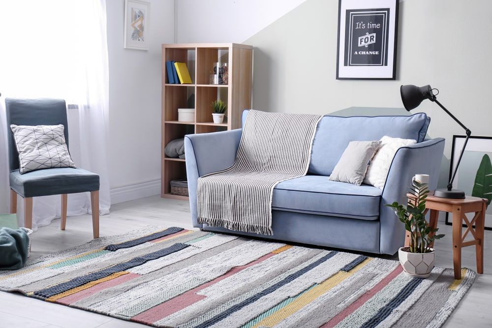 Living Room With A Blue Couch And A Striped Rug — Shane's Painting & Timber Restorations In East Toowoomba, QLD