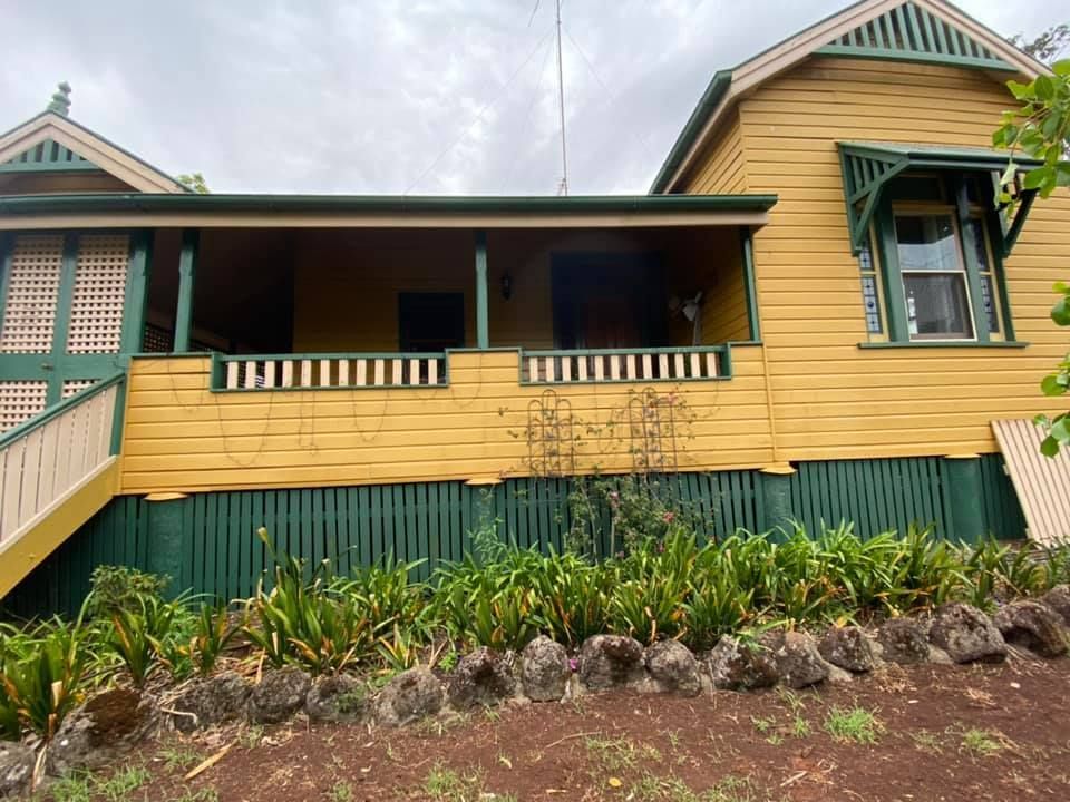 Yellow House With A Green Fence And Stairs— Shane's Painting & Timber Restorations In Gatton, QLD
