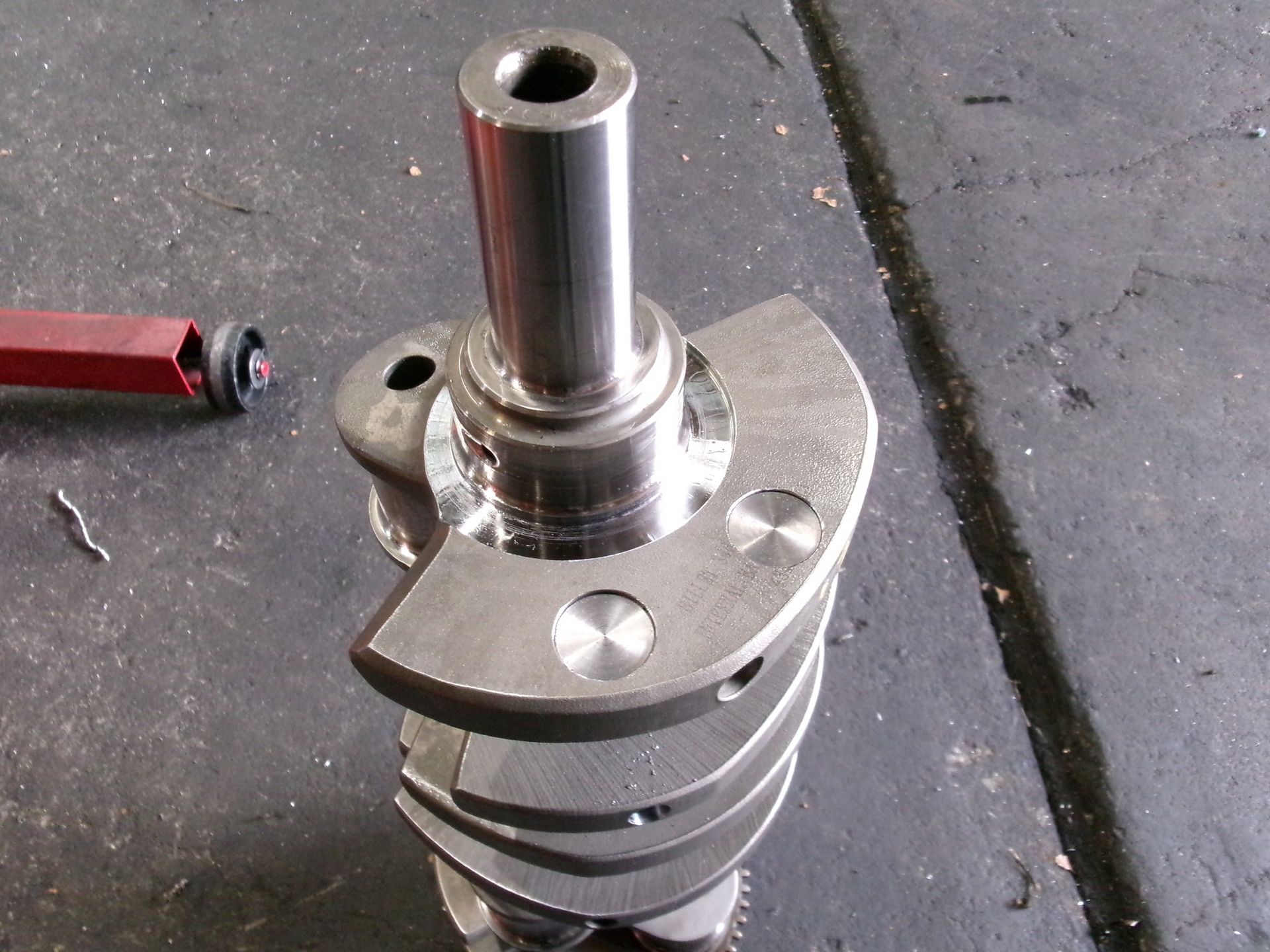 A close up of a metal crankshaft on a table