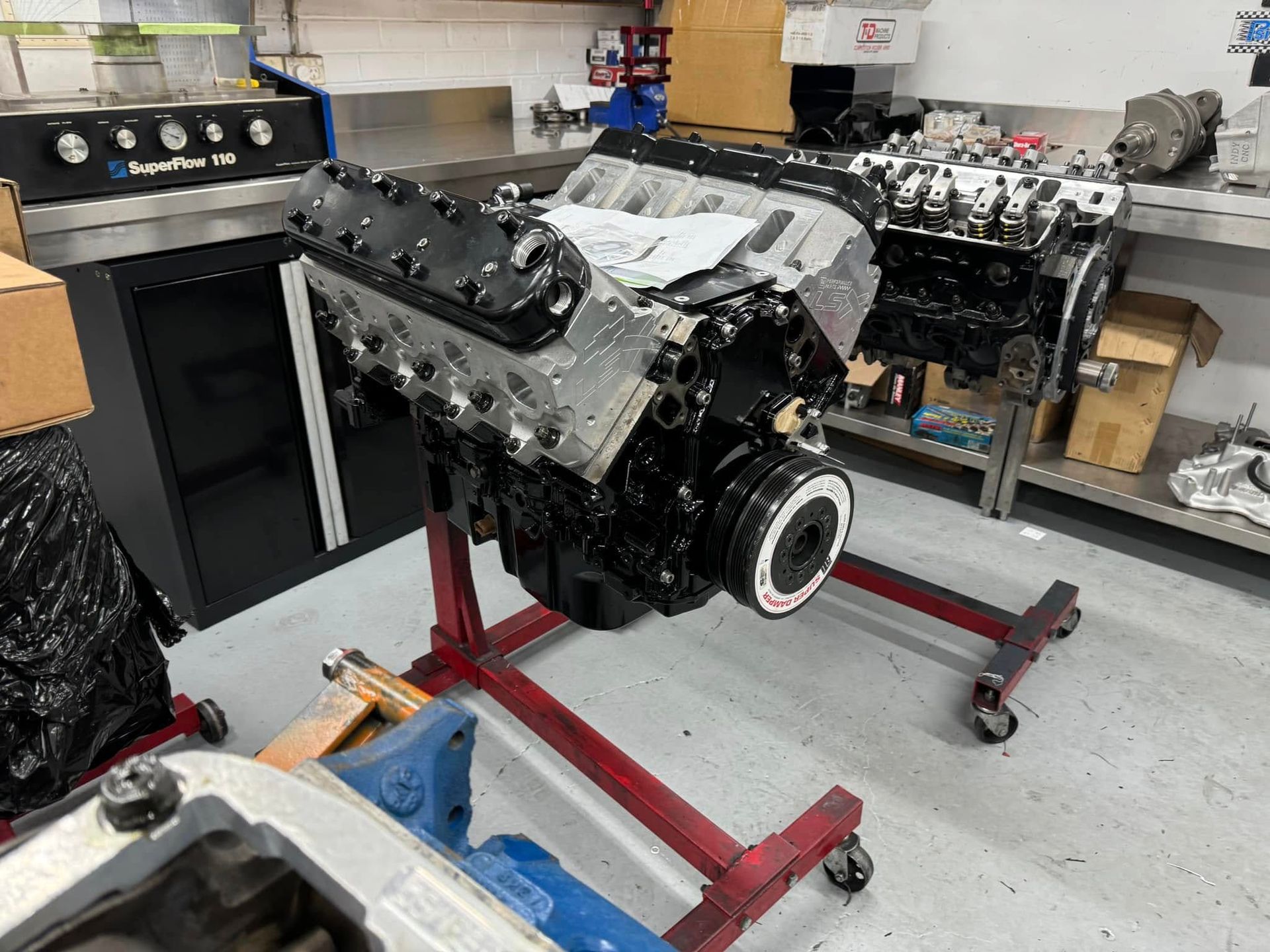 A large engine is sitting on a stand in a garage.