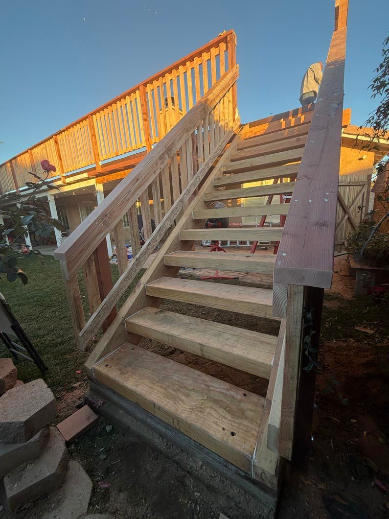 Outdoor wooden stairs with a handrail, lit by warm sunset light.