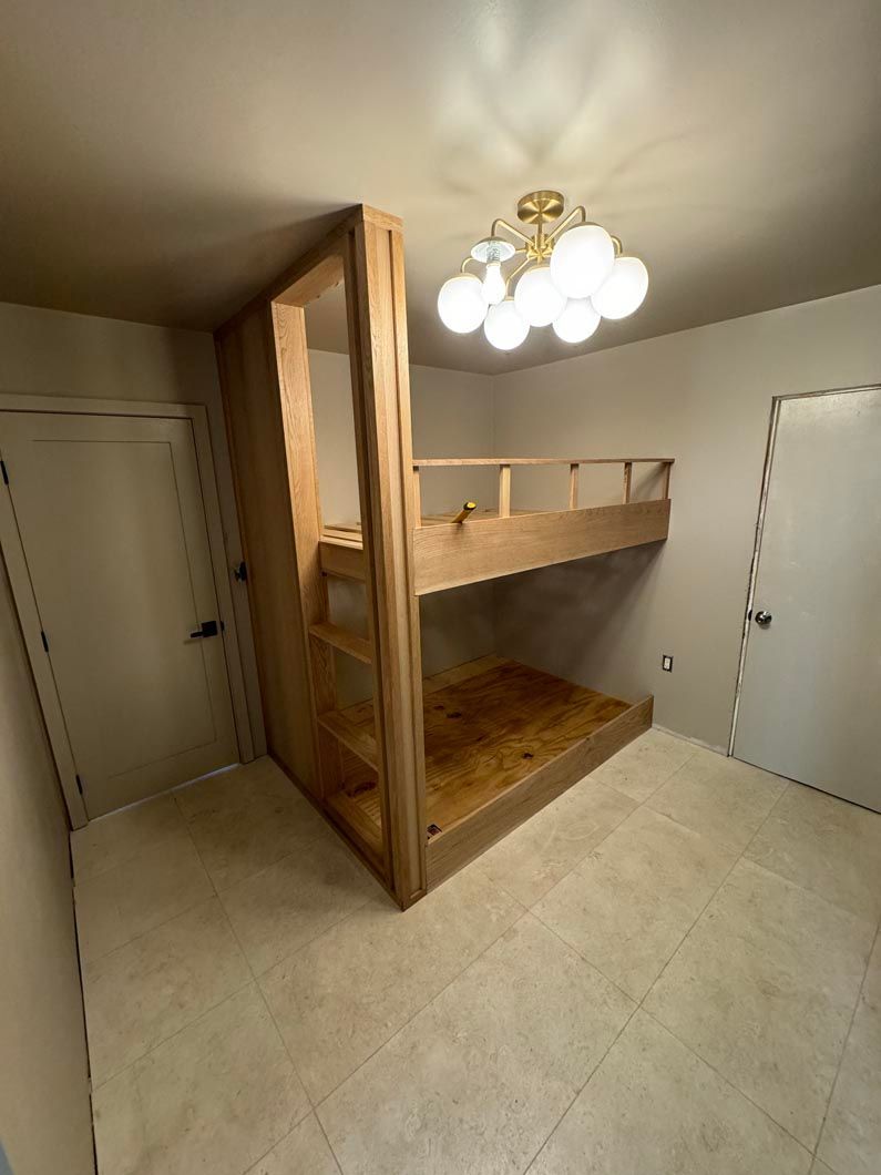 Small room with a wooden bunk bed, tile floor, and ceiling light fixture