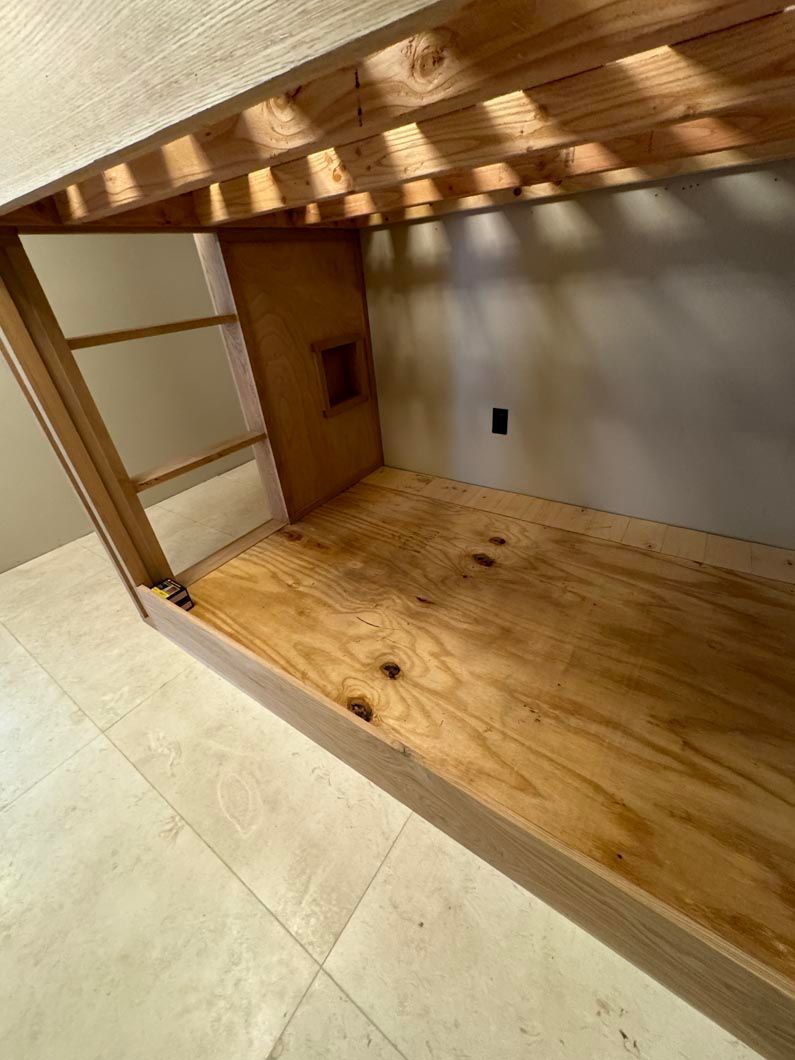 Small empty wooden alcove with a sliding door, frosted panels, and a tiled floor under warm lighting