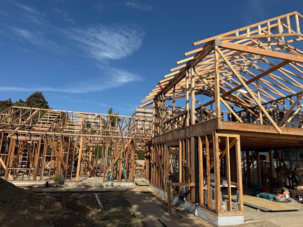 Wooden house framing under construction under a blue sky
