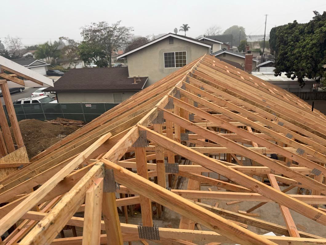 Wooden house roof framing under construction in a residential neighborhood