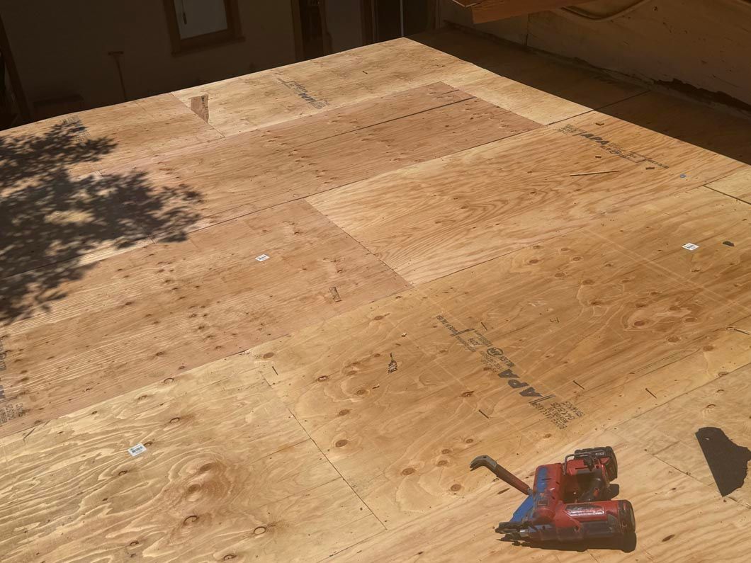 Sunlit wooden deck with a red-and-black power drill on the lower right