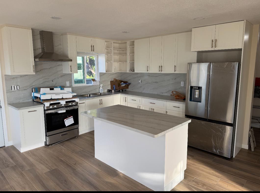 Bright modern kitchen with white cabinets, stainless steel appliances, and a gray island.