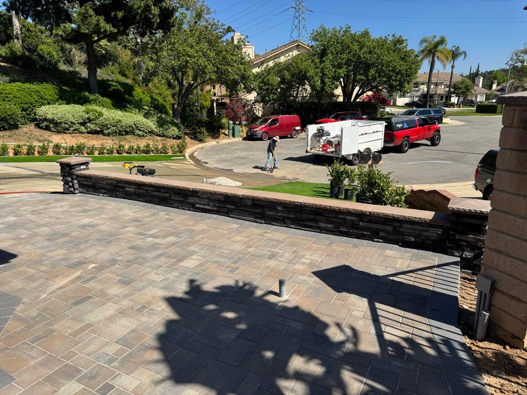 Driveway with red cars, white van, and palm trees in a sunny residential courtyard