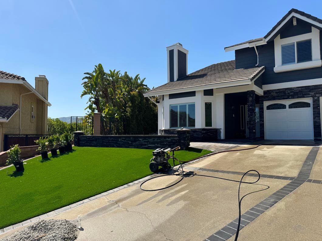 Suburban house with manicured green lawn, driveway, and a motorcycle parked in front.