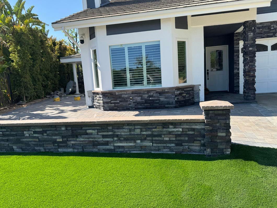 Modern house exterior with stone accents, white walls, and a green lawn in front