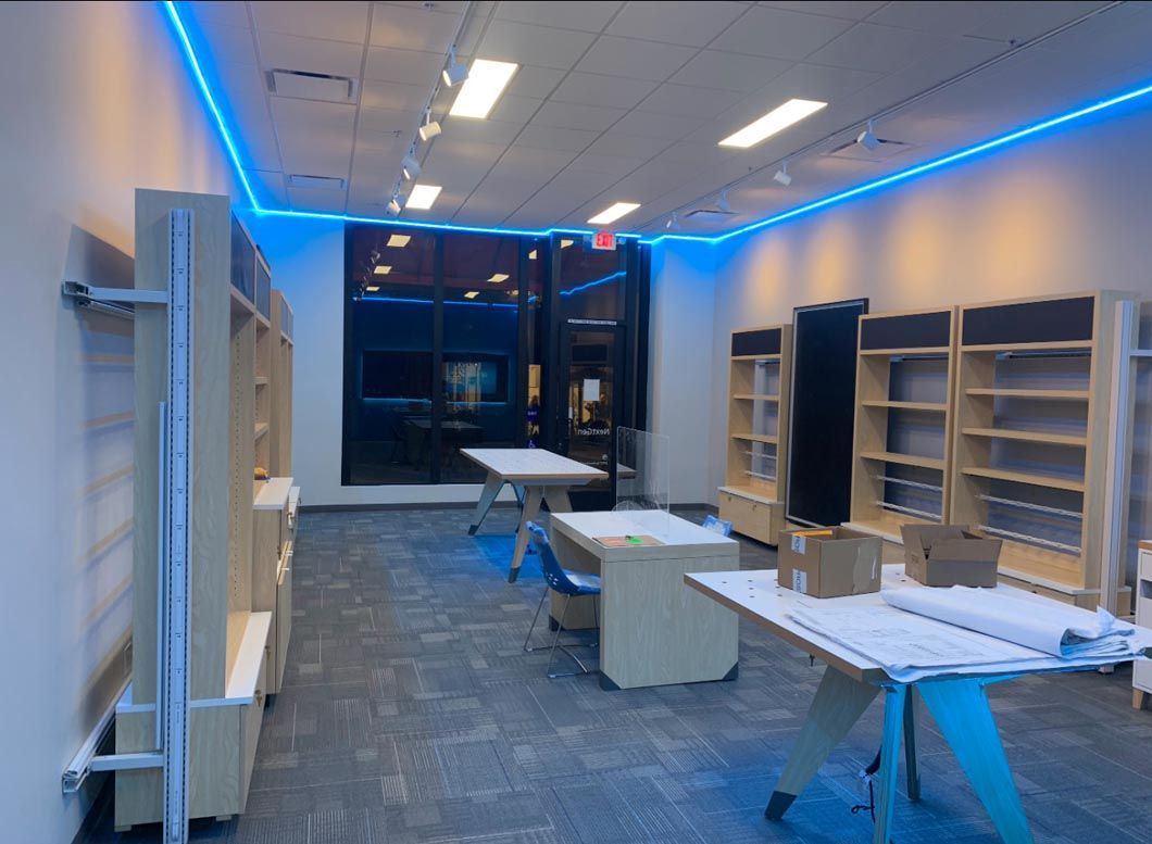 Modern room with shelves, tables, and blue LED ceiling lights