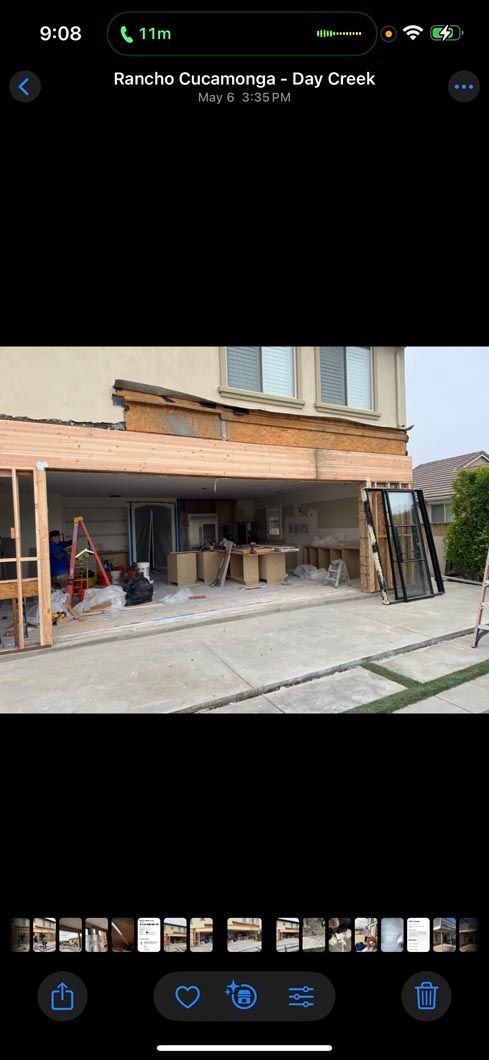 Small storefront with an orange awning, open entrance, and a person sitting under the porch.