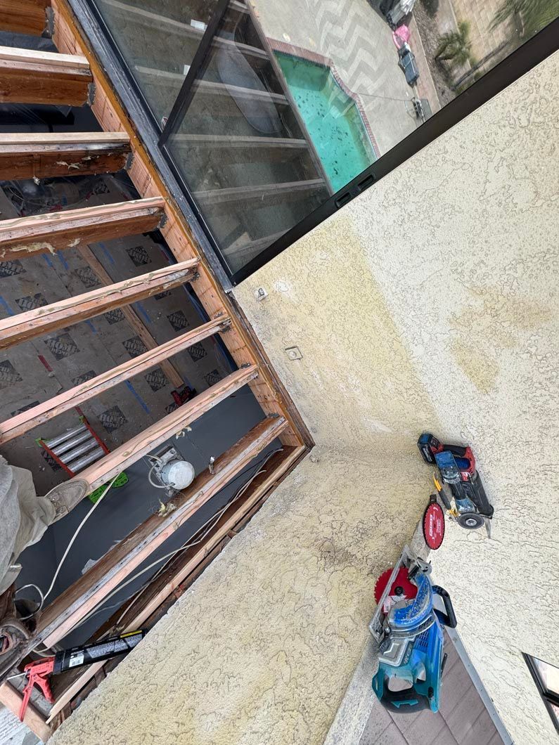 Staircase next to a rough concrete wall with two sandals and a blue bag on the floor