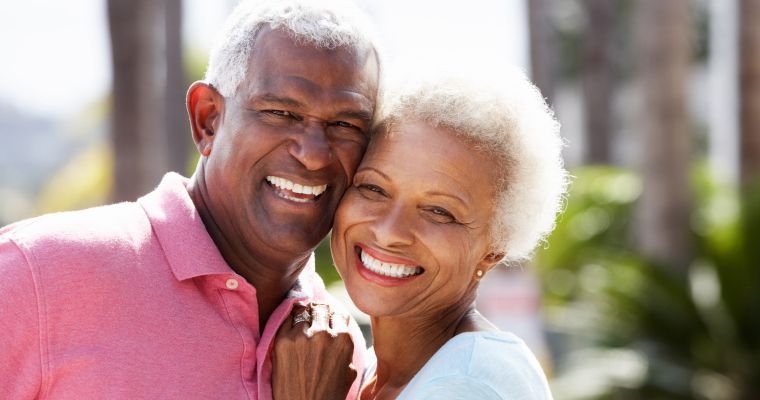 Dental Implant Pain and the Recovery Period with Modern Dentistry of New England A mature couple embrace and smile after his dental implant procedure.