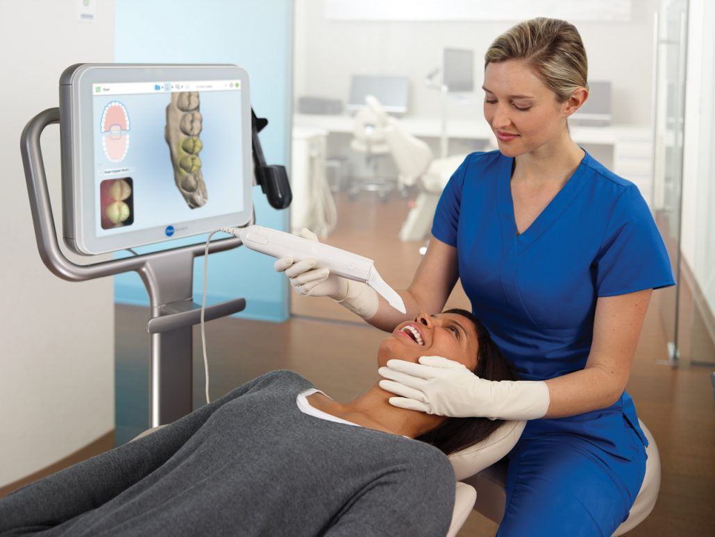 A woman is getting her teeth examined by a dentist